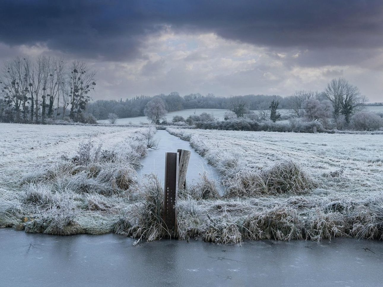 Vista del lago de montaña al amanecer, cubierto de hielo
